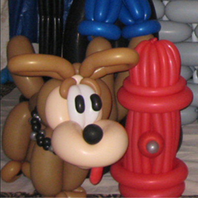 Balloon dog standing next to a balloon fire hydrant.