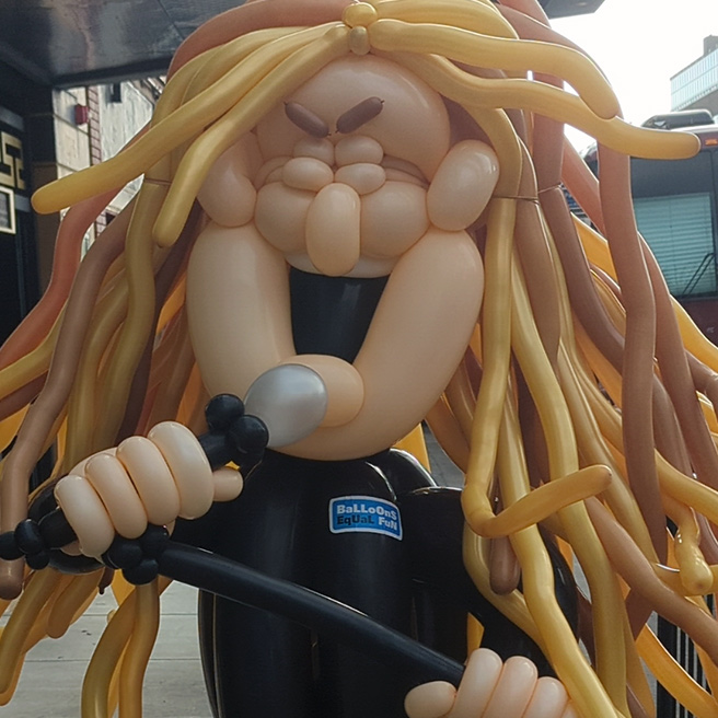 Metal singer belting out a tune into a microphone with his eyes squeezed shut.